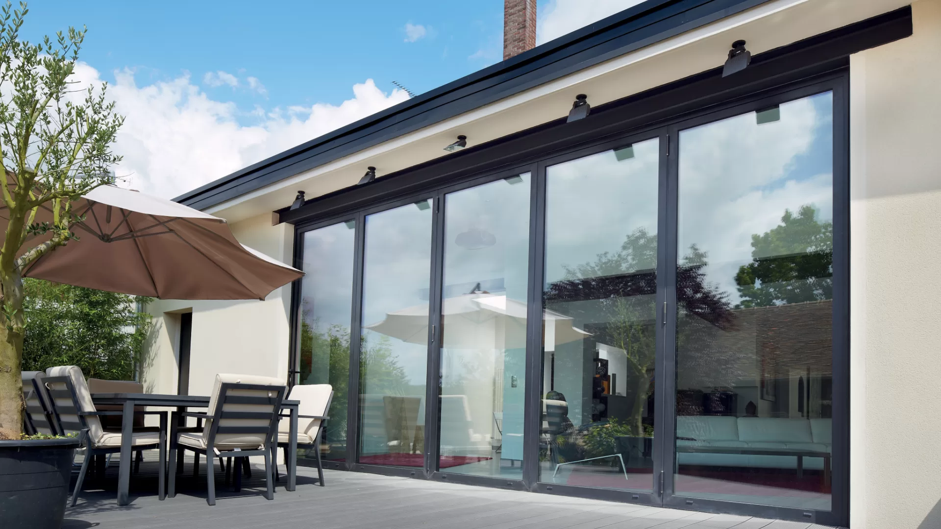aluminium bifold exterior door with 5 panels, looking out onto a modern patio.