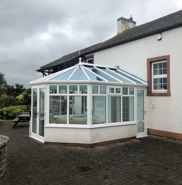 Conservatory extension on the rear of a home, with white frames.