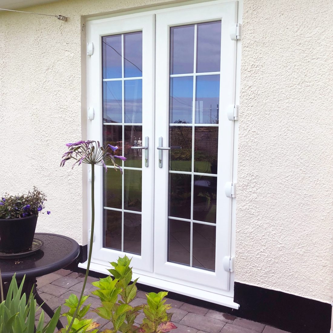 Double French doors in white with bar detailing on windows.