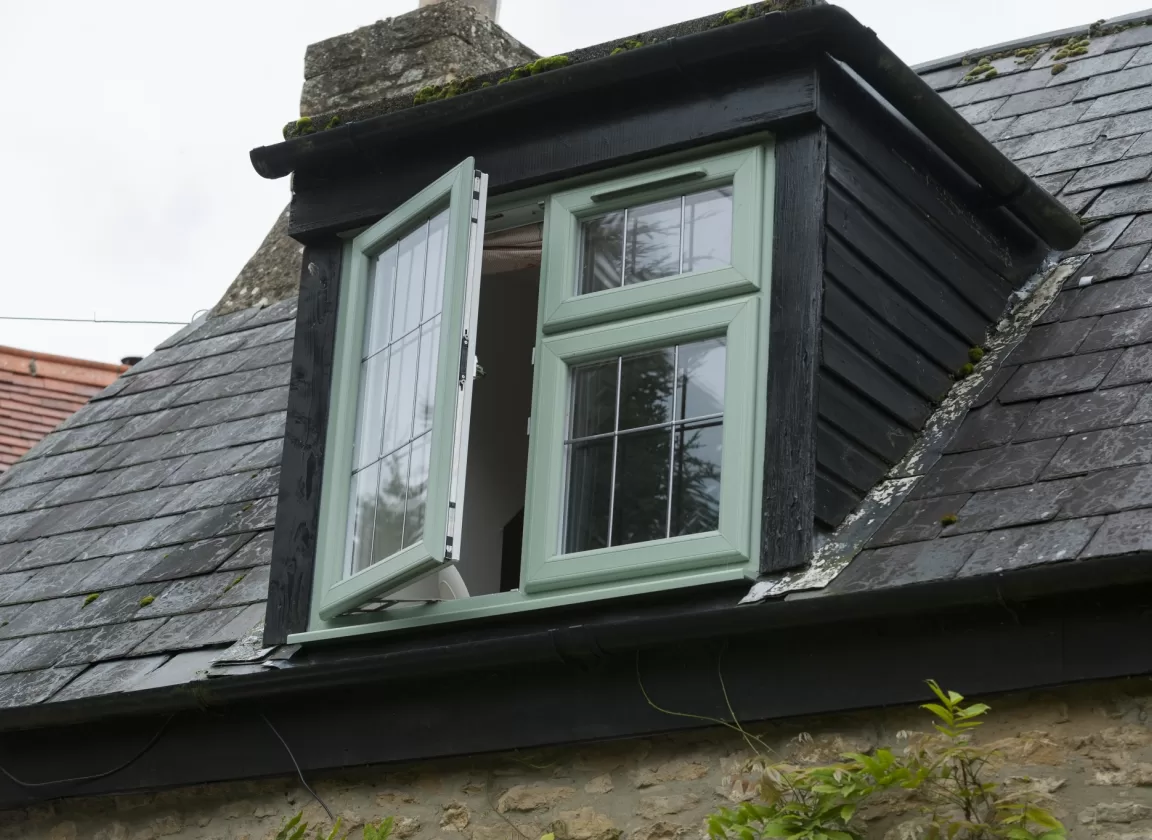 Green uPVC casement window open ajar, with Georgian bars