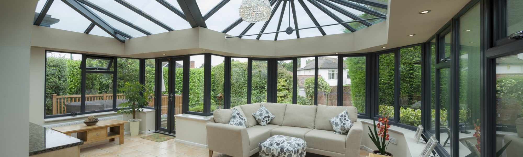 Interior of an orangery conservatory extension, featuring kitchen counter top and modern, stylish furniture.