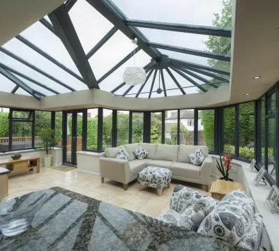 Interior of an orangery conservatory extension, featuring kitchen counter top and modern, stylish furniture.