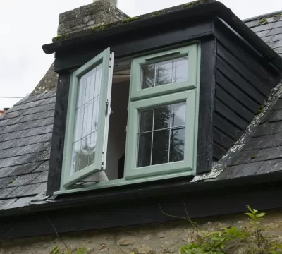 Green uPVC casement window open ajar, with Georgian bars