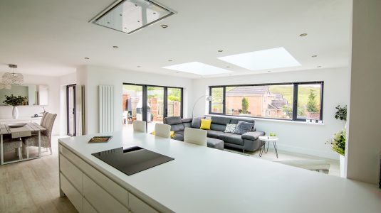 Modern and bright home interior of an open plan kitchen and living room area.