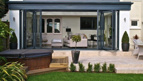 Bifold aluminium doors on an orangery facing into a modern garden.