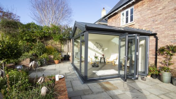 Modern, glass conservatory extension with a solid tiled roof.