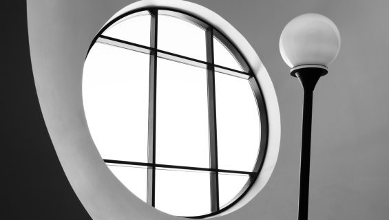 Round porthole window with black aluminium bar detailing.