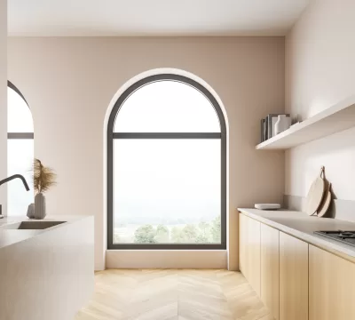 Large arched window with dark grey frames, in a modern and minimalist kitchen